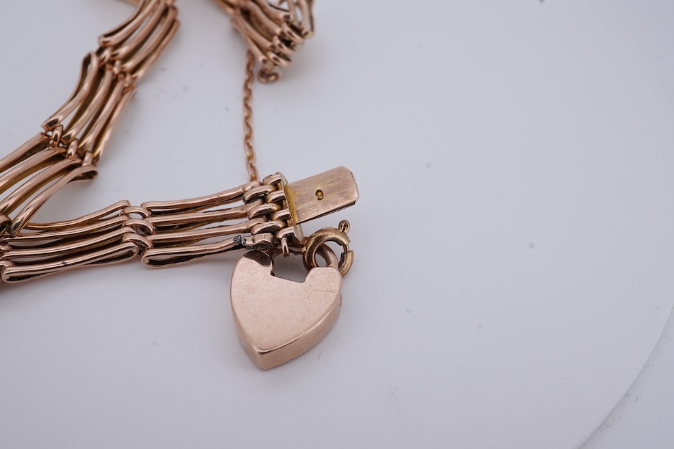 An early 20th century yellow metal gate link bracelet, with heart shaped padlock clasp on safety chain, stamped '9', approx. 18cm, 9.2 grams. Condition - poor